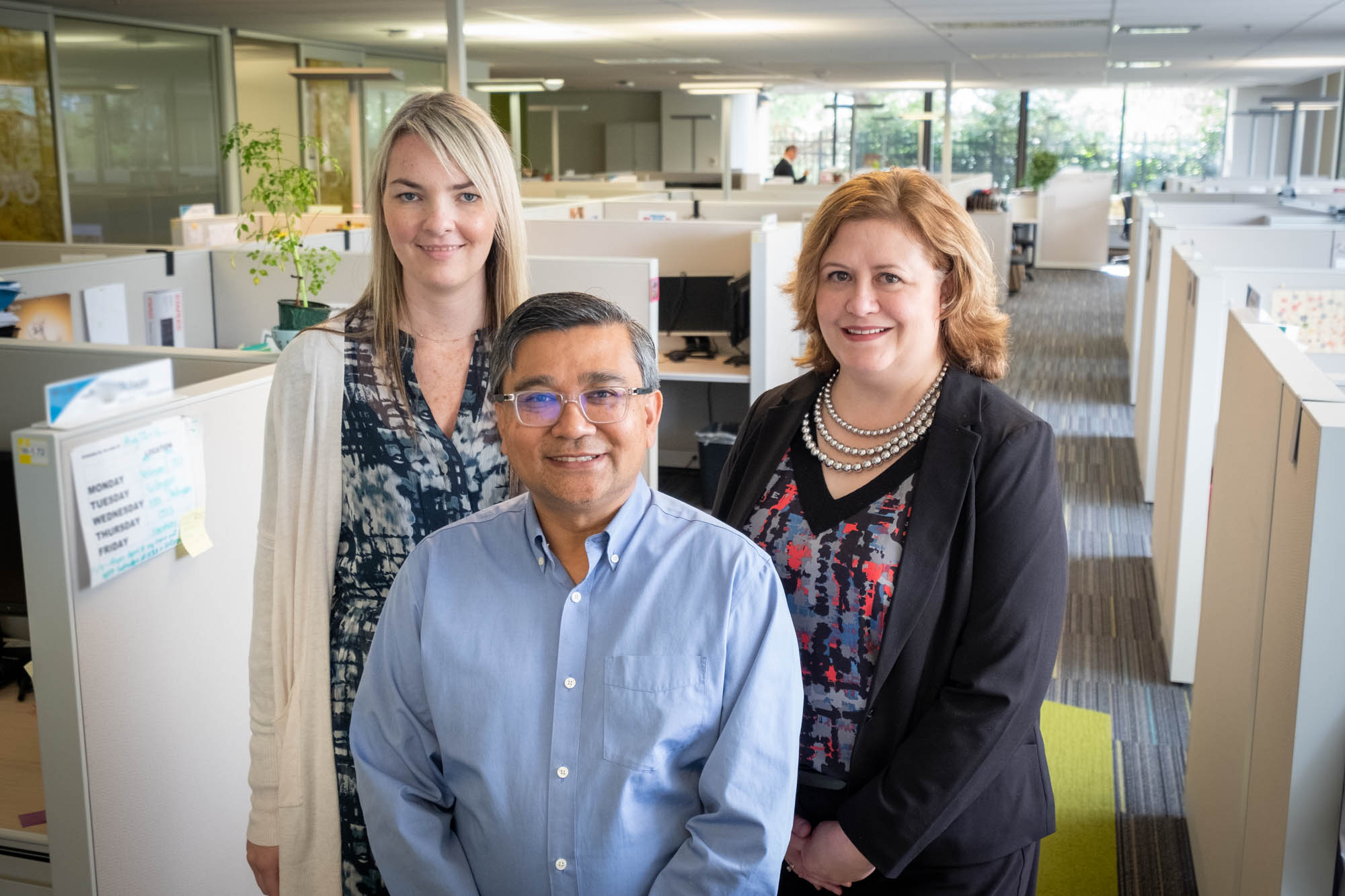 Two women and a man in an office building