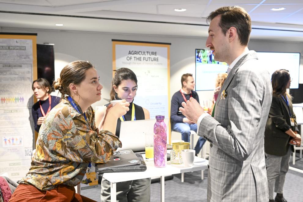 a man and a woman standing at a table having a conversation