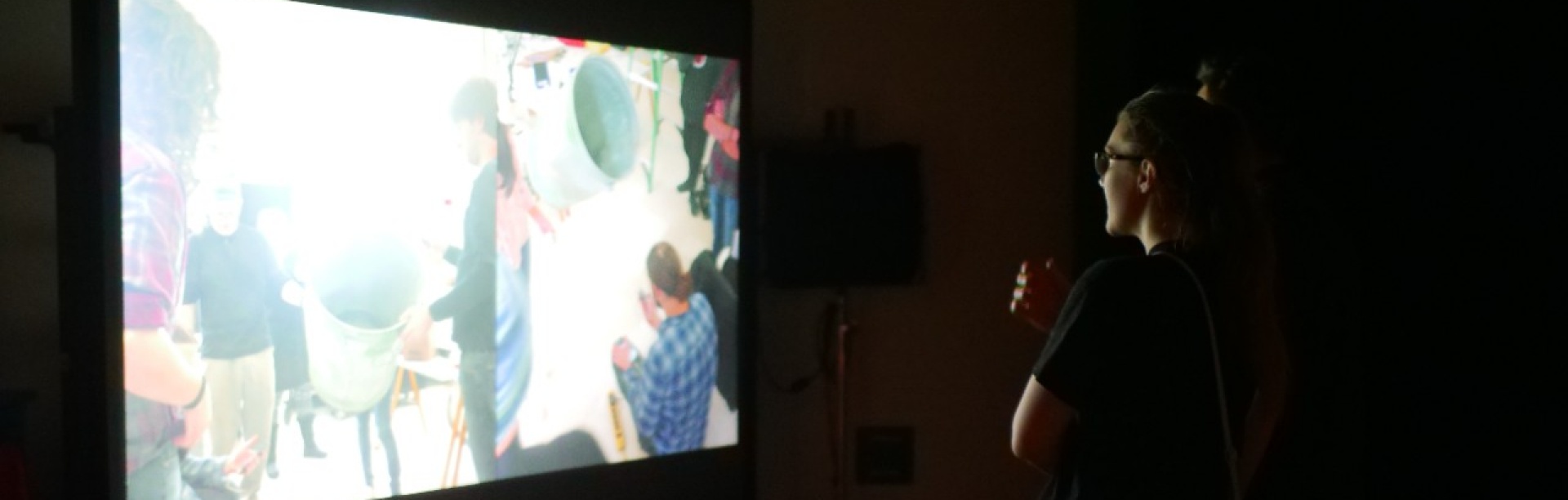 Students viewing a screen in a dark room. 