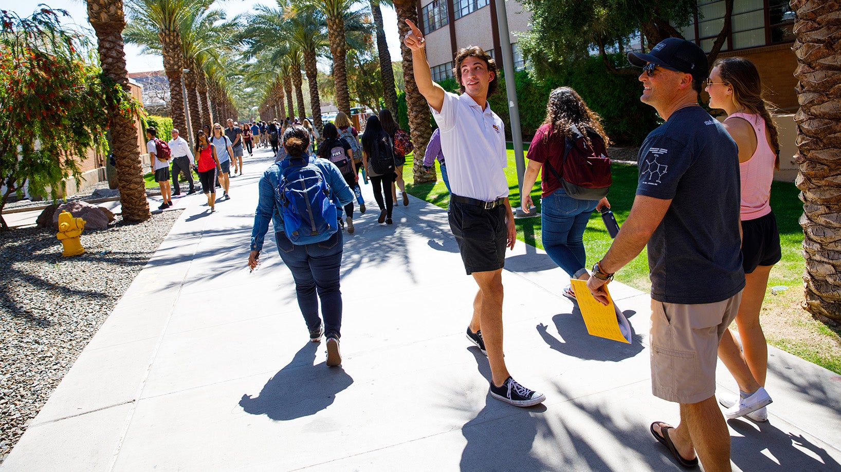 ASU staff showing prospective student and family around the ASU campus