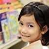 Girl Looking Back in Front of Bookshelf