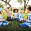 Kids Playing Together While Sitting in the Grass