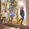 Kids Walking on Lying Trunk in Forest