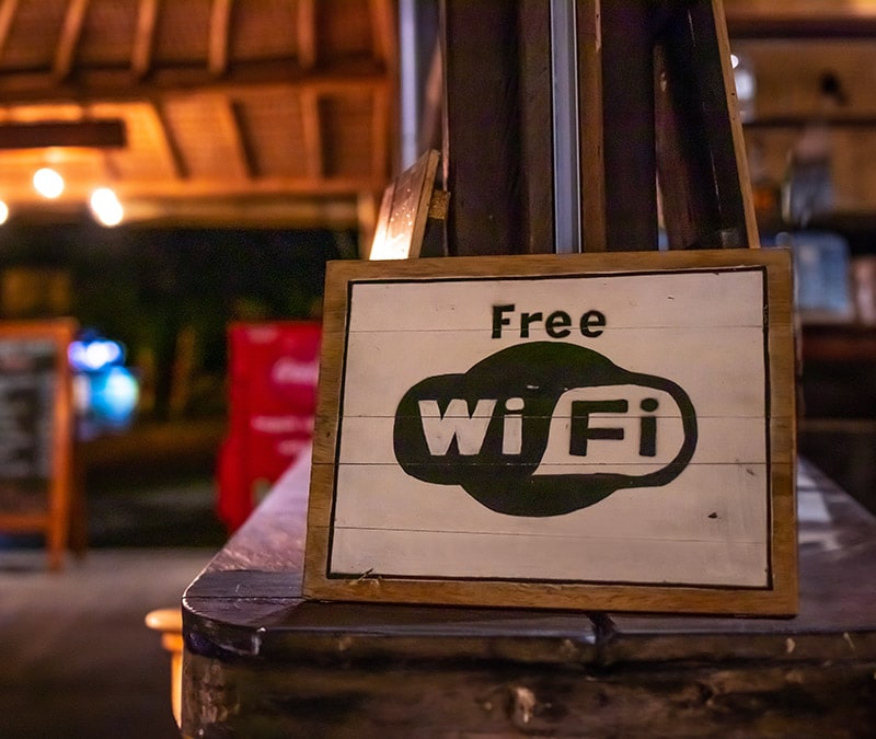 Ein Schild "Kostenloses WLAN" an der Tür eines gemütlichen Abendlokals wirft die Frage auf: Ist kostenloses WLAN sicher?