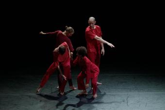 Four dancers in red on a stage