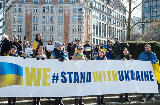 People demonstrating with Stand with Ukraine banner