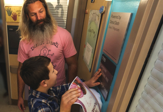 Child and adult giving a high five  outside the playroom