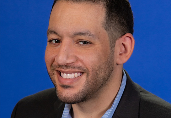 Man with beard and wearing a black suit