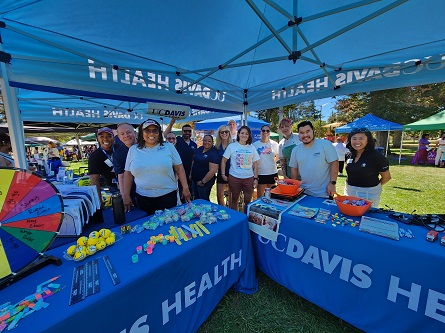 UC Davis Health volunteers pose for a photo at the UC Davis Health booth