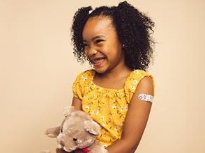 girl with bandaid holding teddy bear