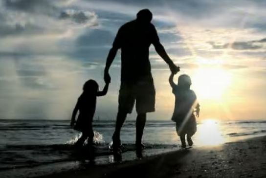 Two adults walking with a child