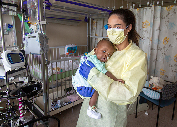 Volunteer Rema Khacho comforts 10 month-old LaMont Eugene as he awaits a visit by his mom.