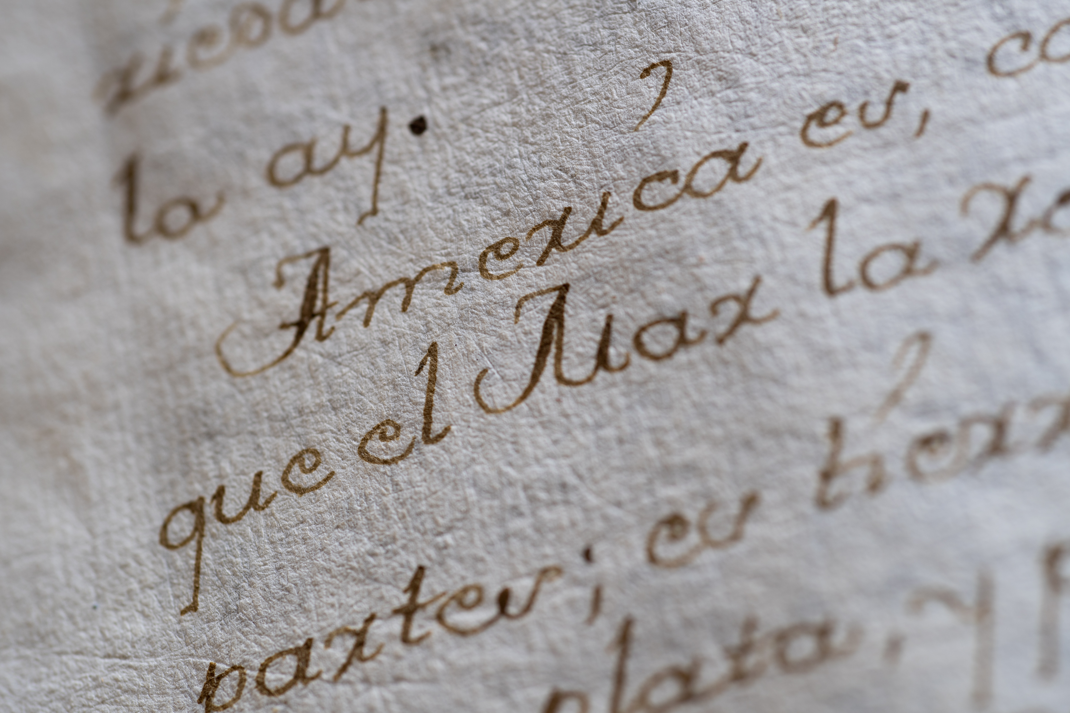 Detail from a manuscript codex shows "America" in focus within a Spanish text.