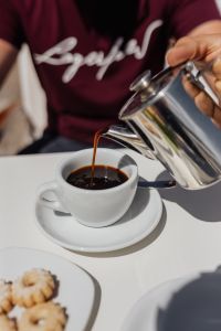 Kaboompics - Pouring coffee into a cup. Silver kettles, Italian cookies.