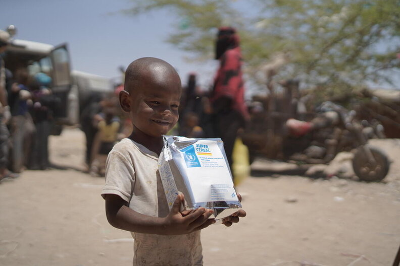 Yemen. Ali Majed, 5, holds a super cereal bag in Ataq District