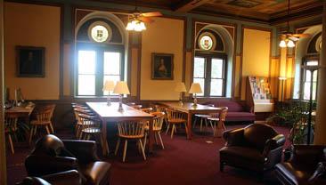 A corner of the Bioethics Research Library, showing tables and chairs, with light streaming in through the windows