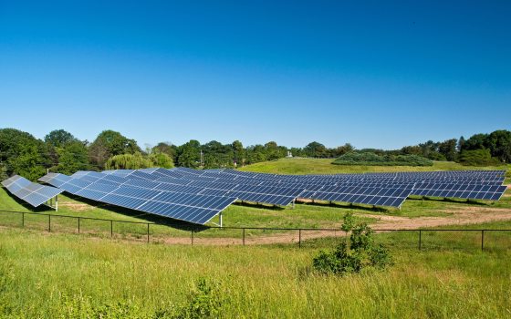 solar panels placed in a large, sunny field