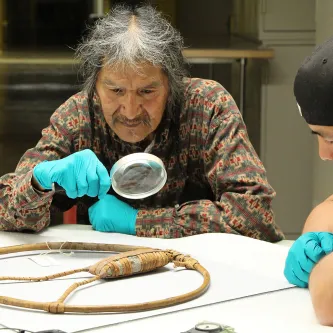 Wanapum tribe member examines object with magnifying glass