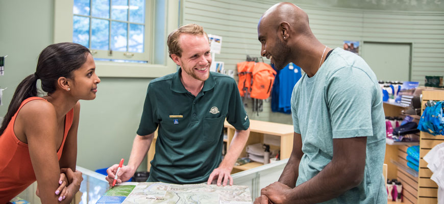 Parks Canada employee giving information to visitors at the Banff Information Centre.