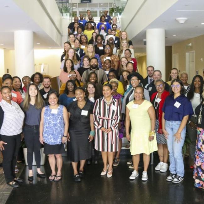 Individuals participating in the 2023 cohort are lined up on a stairwell. 