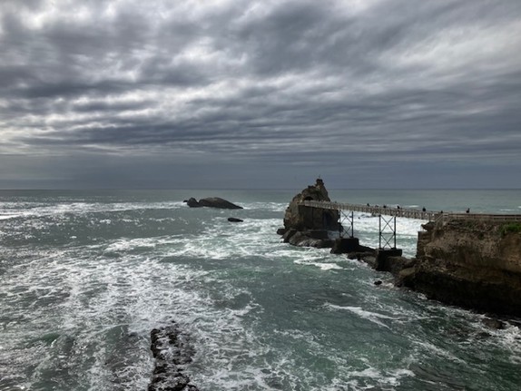 Meer zwischen Felsen und dunklen Wolken