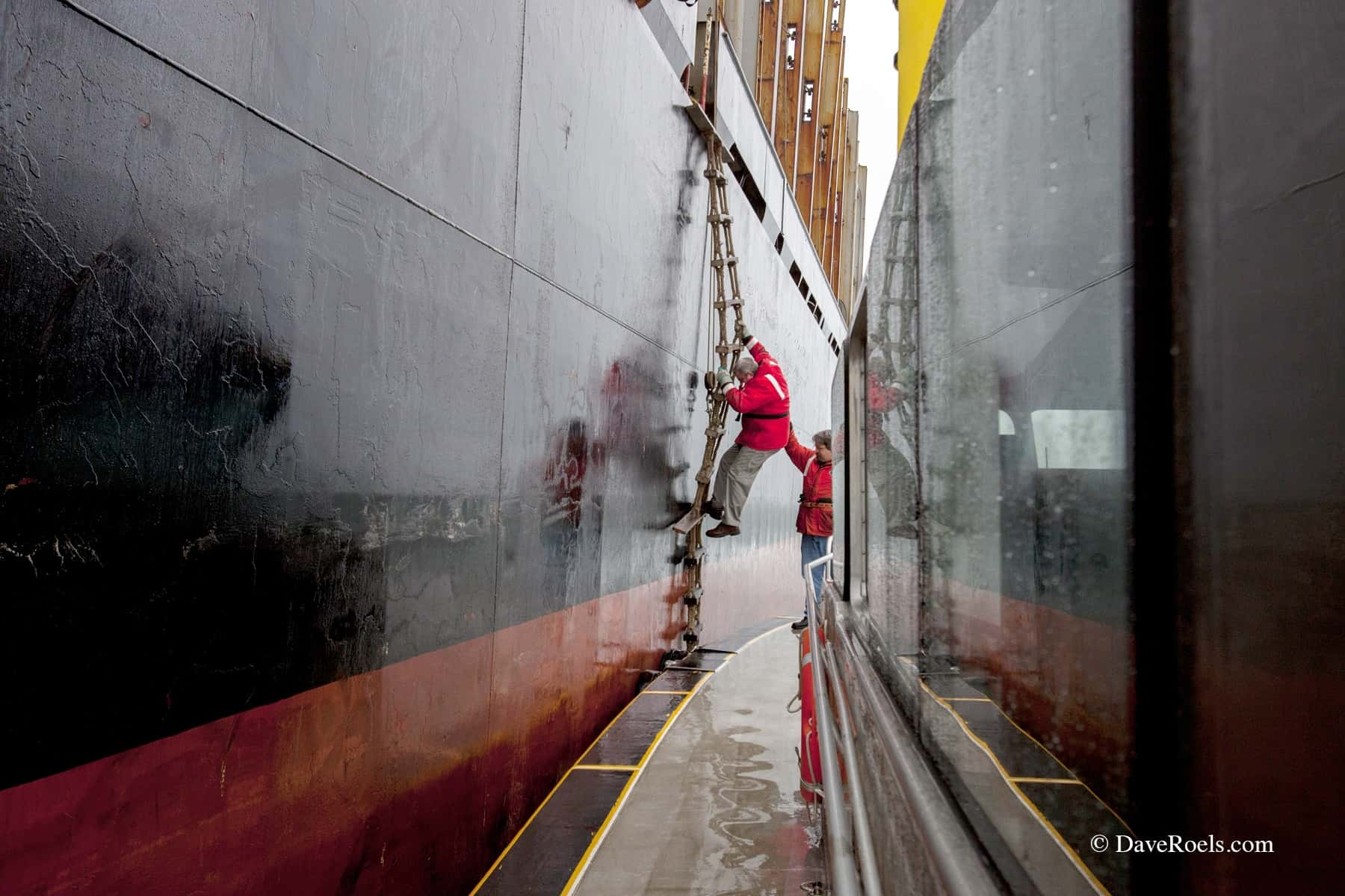 Man climbing down side of boat