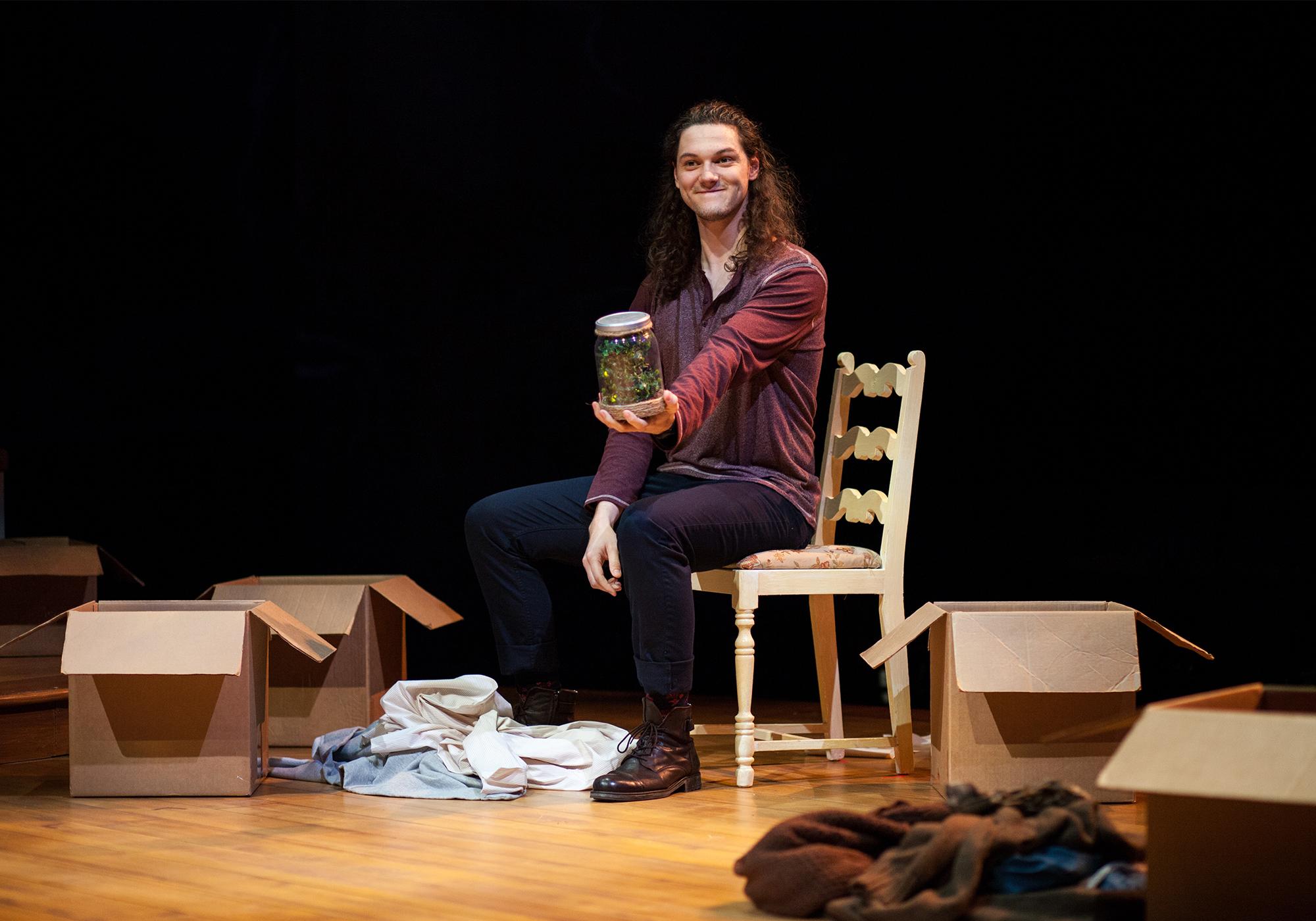 man sitting down holding firefly jar