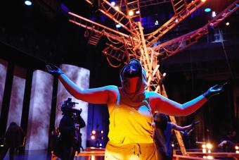 dancer in yellow in front of ladder strucutre