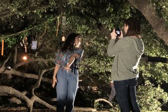 director records an ensemble member performing a dance in front of trees