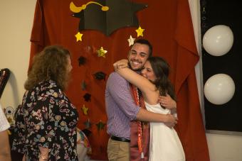 graduates hugging one another