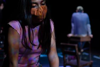 actress looking down wearing a mask and colorful barrettes