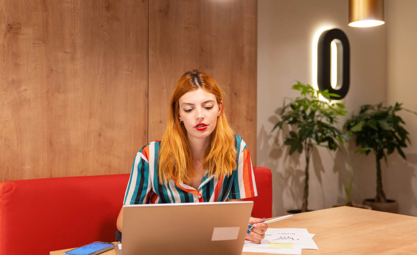 girl sitting at laptop checking her unknown transactions.