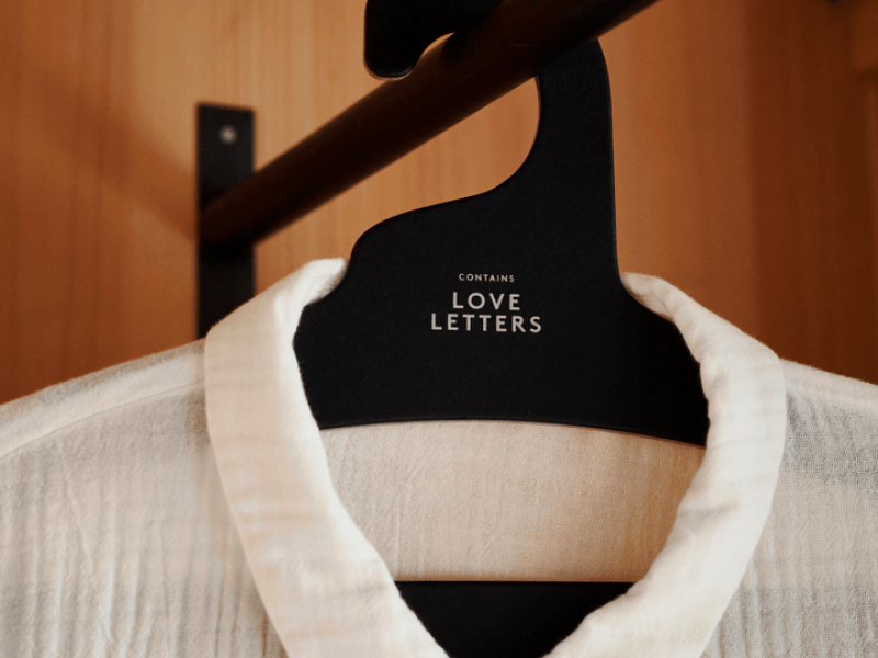 A white linen shirt with collar, hung in closet