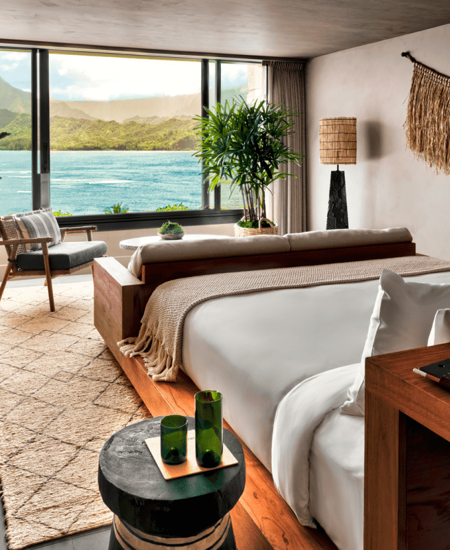 A bedroom with a view of the ocean just outside