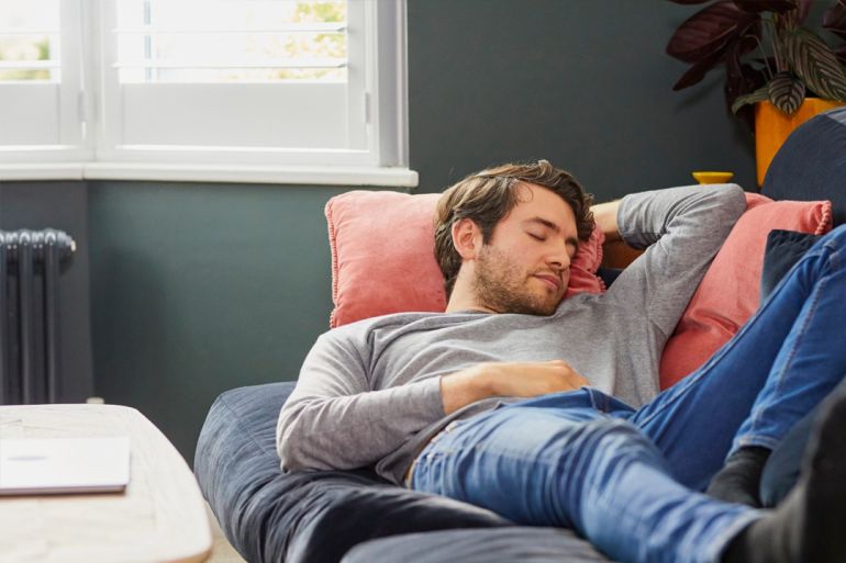 handsome man asleep in velvet sofa at home