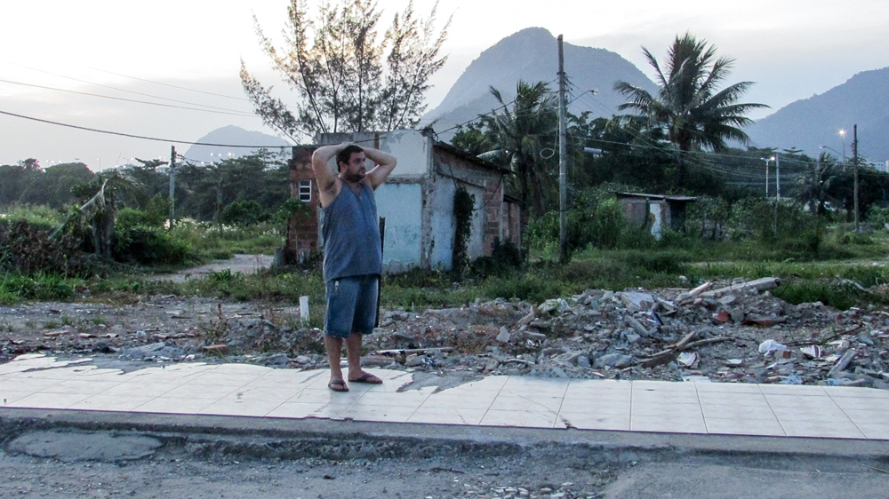 A resident stares at the rubble of former homes [Maya Thomas-Davis/Al Jazeera]