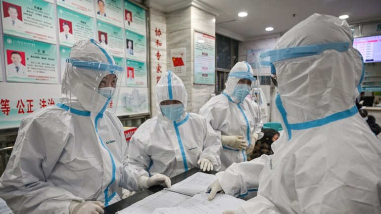 Medical staff members wearing protective clothing to help stop the spread of a deadly virus which began in the city, work at the Wuhan Red Cross Hospital in Wuhan on January 25, 2020. - The Chinese ar