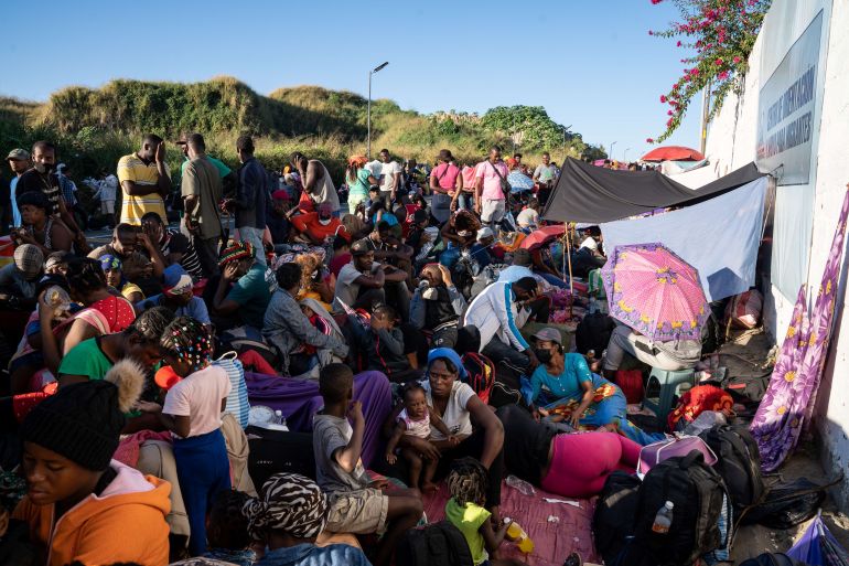 Haitian asylum seekers wait on the side of a road in Tapachula, Mexico