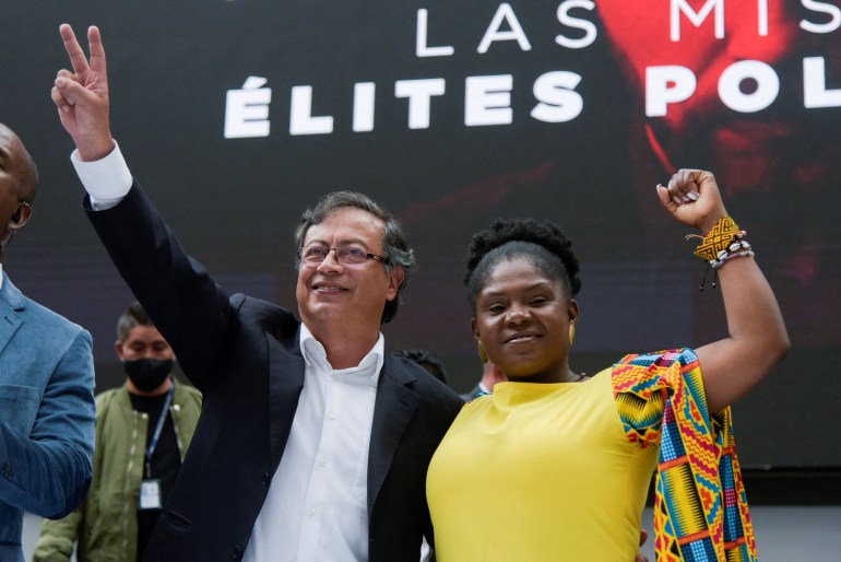 Gustavo Petro and his VP candidate Francia Marquez gesture at a crowd