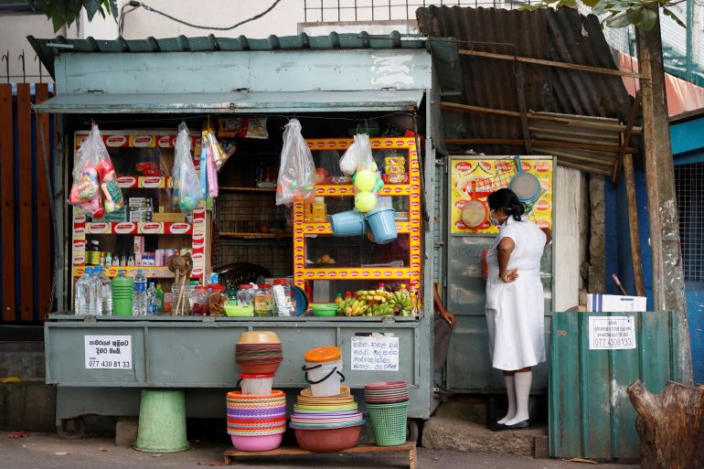 A medical worker talks to a vendor selling household goods and food for patients and their family members, outside Apeksha Hospital, Colombo, Sri Lanka.