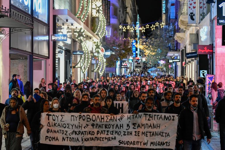 Protesters hold a banner which reads in Greek "they shot them because they were Roma" as they protest the shooting in the head of a 16-year-old youth, in central Athens Monday Dec 5, 2022. A police officer has been arrested in northern Greece after a 16-year-old boy was shot in the head and seriously injured during a car chase after he allegedly failed to pay the bill at a gas station(AP Photo/Michael Varaklas)