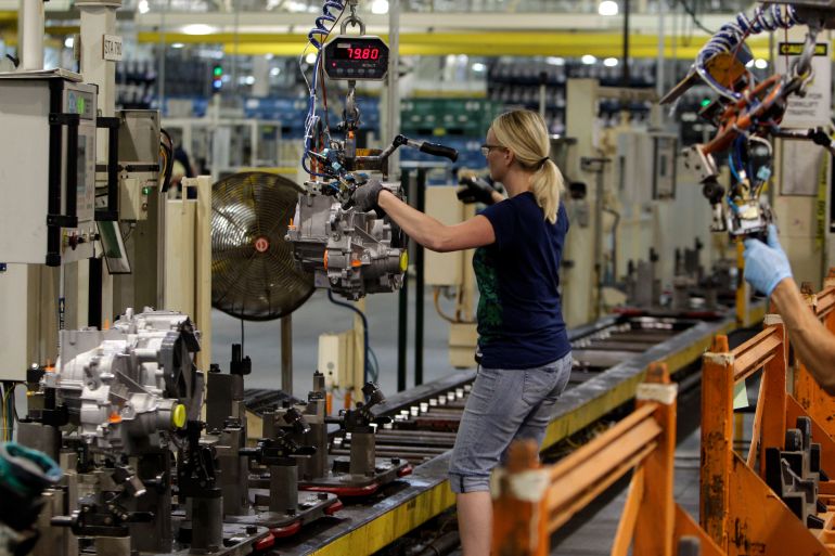 Line worker Cheryl Simpson moves a transmission from the assembly line to a pallet at the Ford Van Dyke Transmission Plant in Sterling Heights, Michigan, US