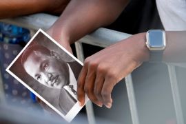 A person holds an image of Dr Martin Luther King Jr as they listen to speakers during the 60th Anniversary of the March on Washington at the Lincoln Memorial in Washington on August 26, 2023 [AP/Andrew Harnik]