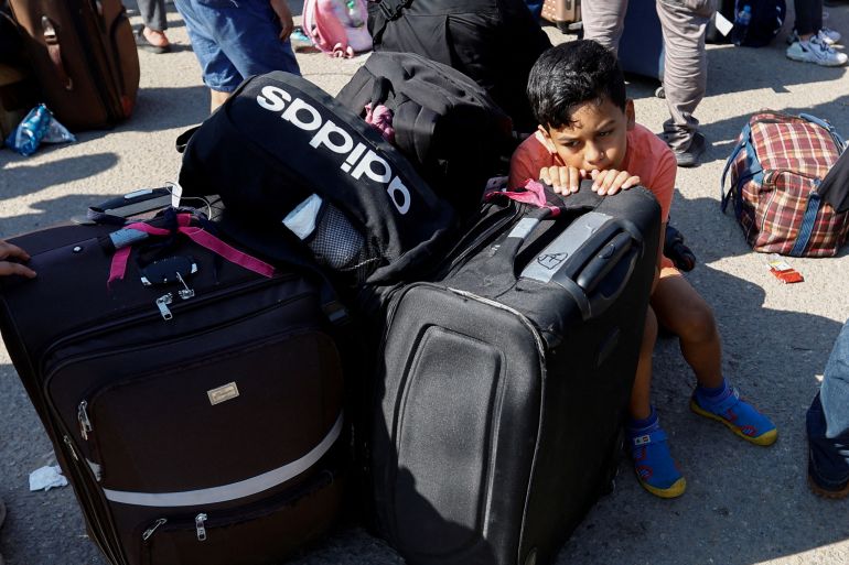 A child rests on luggage as Palestinians with dual citizenship gather outside Rafah border crossing with Egypt in the hope of getting permission to leave Gaza, amid the ongoing Israeli-Palestinian conflict, in Rafah in the southern Gaza Strip