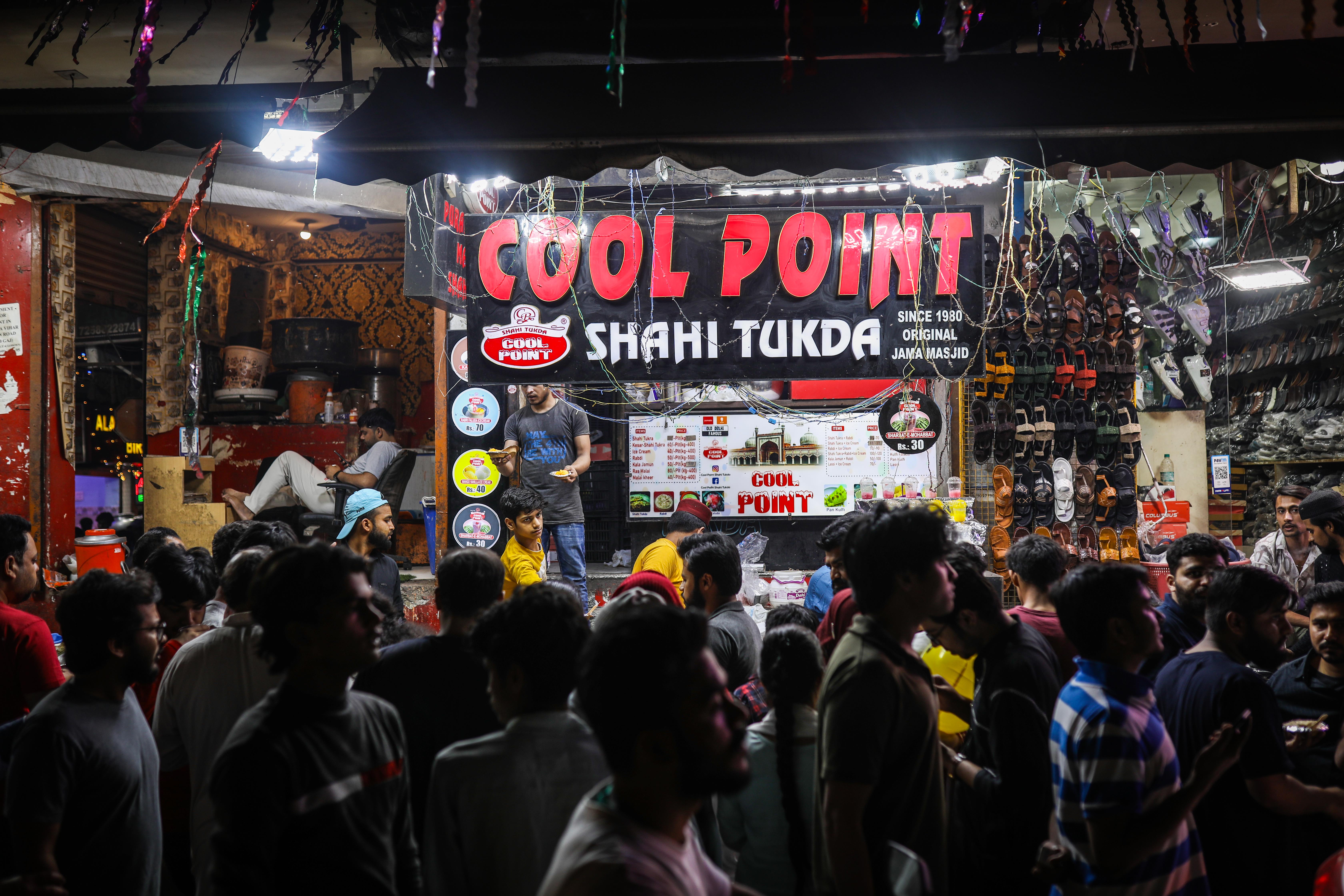 Crowds gather at a dessert stall. [Meer Faisal/Al Jazeera]