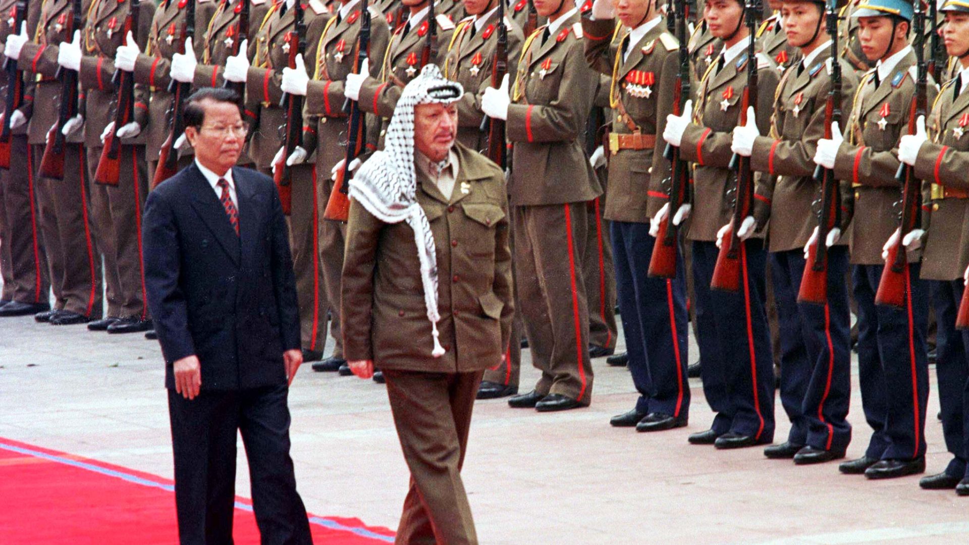 Palestinian President Yasser Arafat walks with Vietnamese President Tran Duc Luong as he inspects an honour guard at his formal welcoming ceremony in Hanoi April 9. Arafat has been on a whirlwind international tour aimed at gauging support for a unilateral Palestinian declaration of independence once an interim self-rule agreement with Israel expires in May. AJS/DL