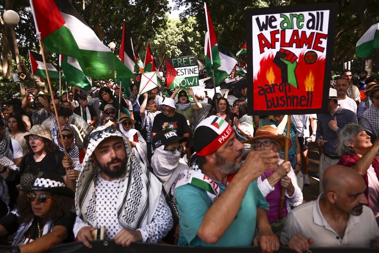 Members of the Australian Palestinian community and supporters wave Palestinian flags as others hold placards and banners during a protest in central Sydney on March 3