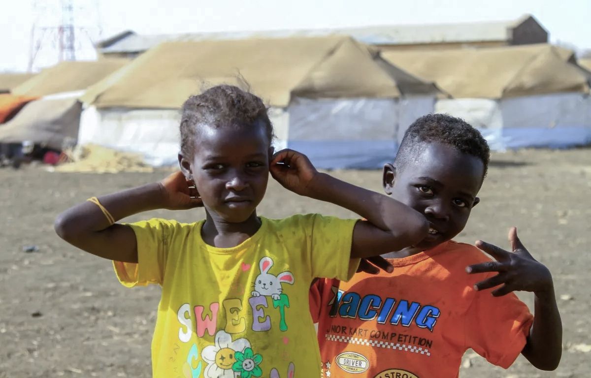 Displaced children who fled Khartoum and Gezira states playing near tents at a displacement camp in southern Gedaref State on March 20, 2024 [AFP]