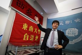 Zhou Fengsuo, curator of the Tiananmen museum in New York.. He is pointing at a banner that was used to bind a student's injuries after they were hit by live fire from the military. The blood stains are clearly visible.