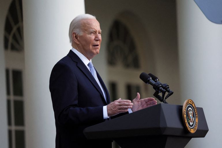 a man in a suit speaks at a podium with the insignia of the US president